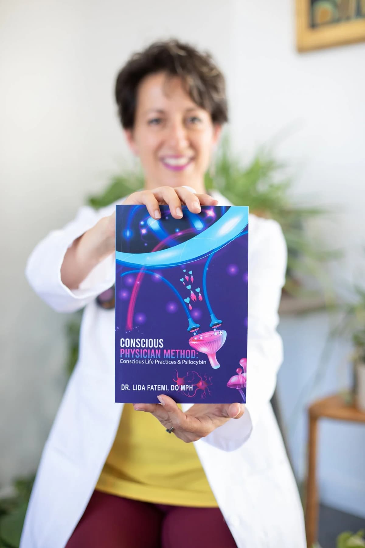 Dr. Fatemi with the Conscious Physicians Method book